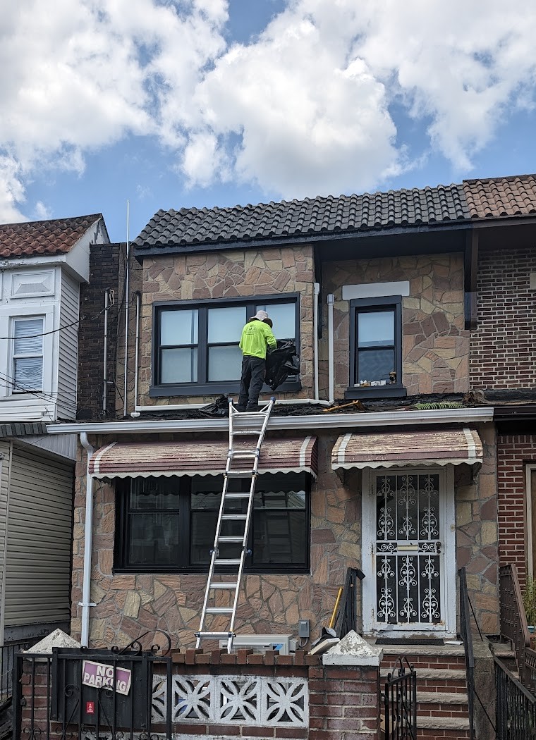 Worker accessing adjoining roof systems below retained clay tile