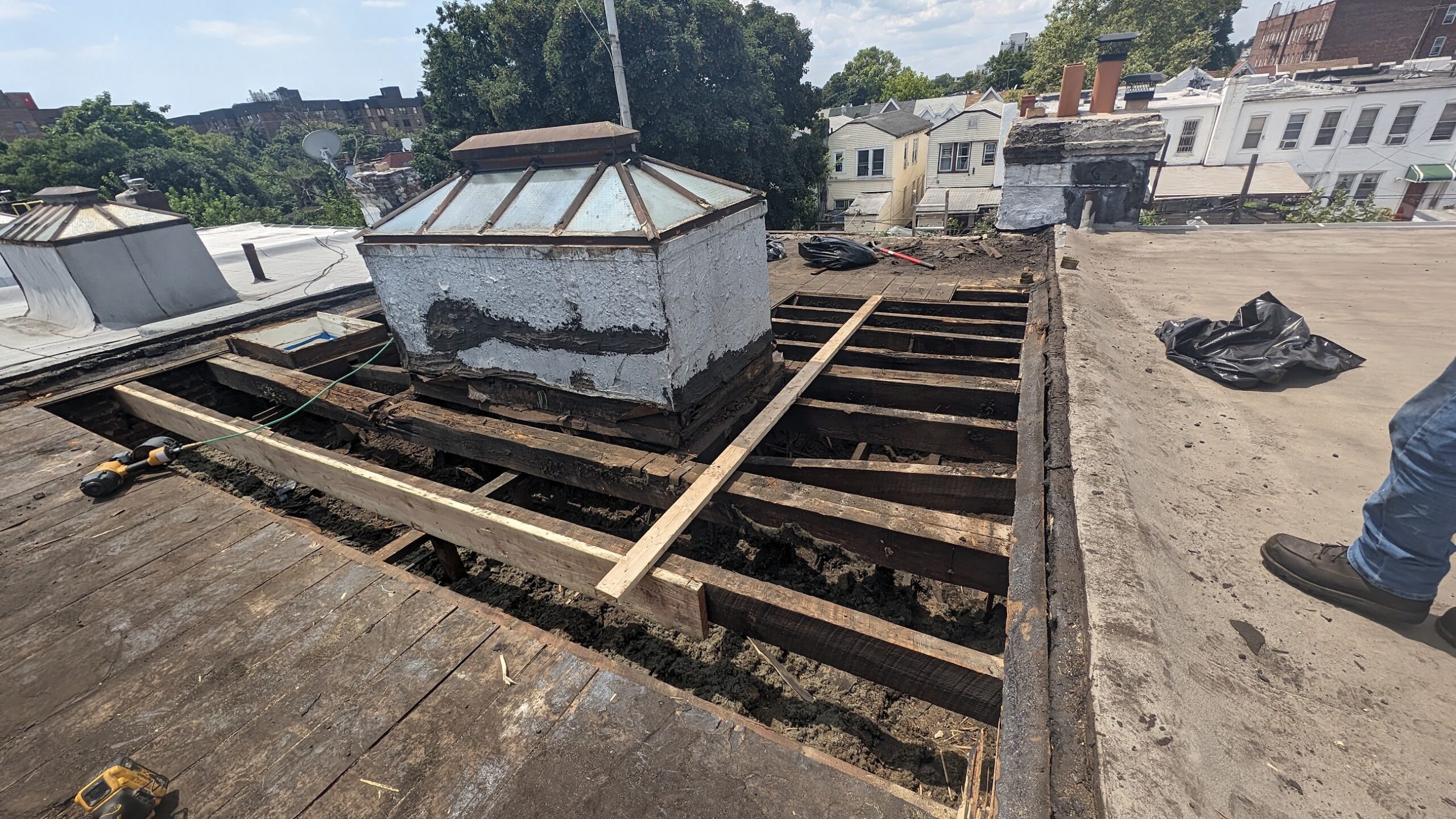 Wide view of opened roof deck and framing during structural repair work