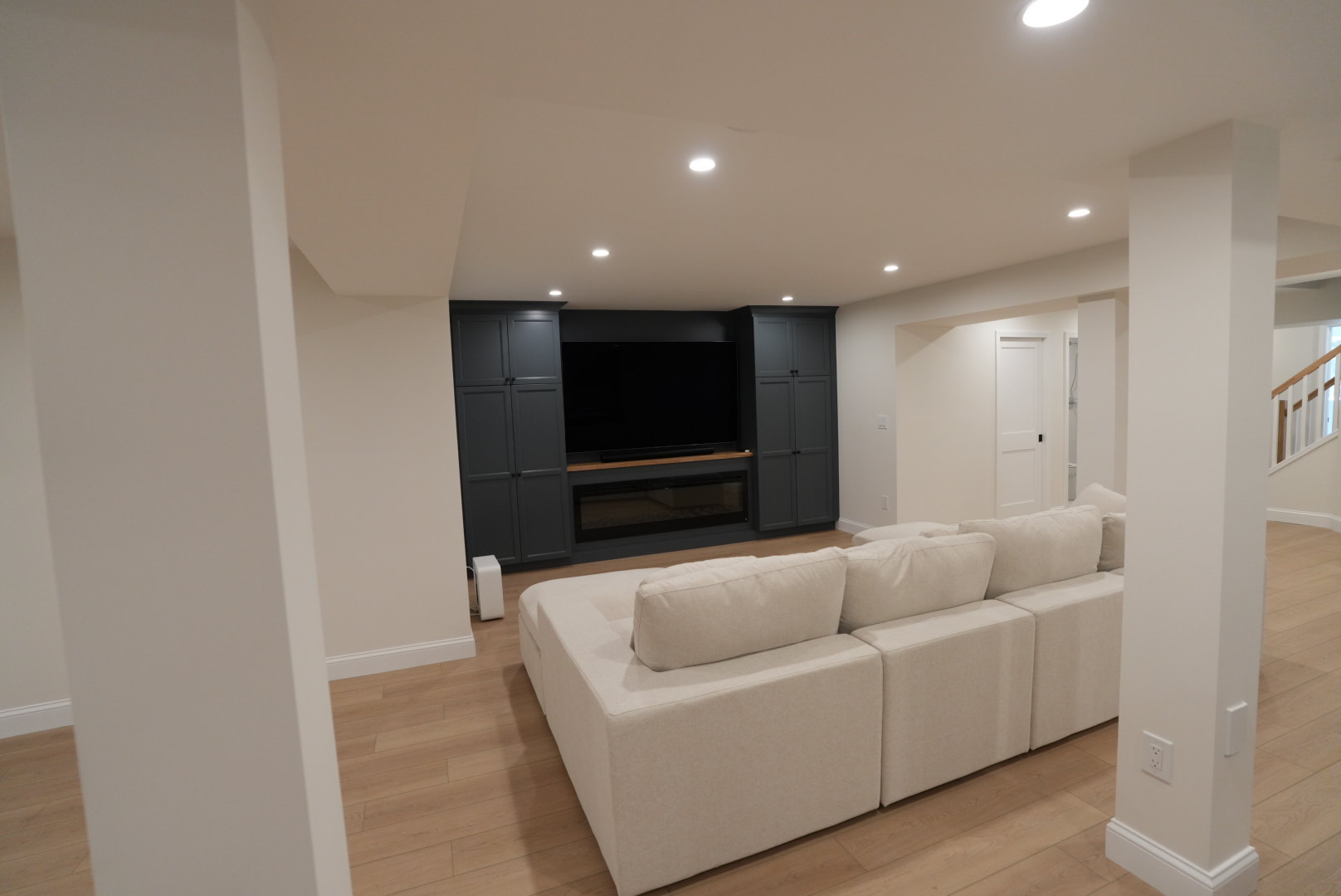 Completed Kellets basement renovation with custom media wall and open living area