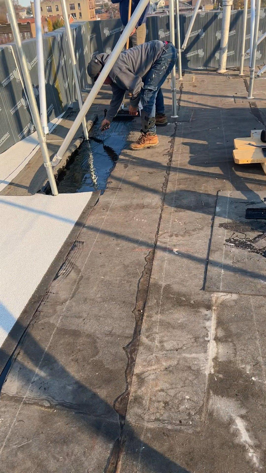 Kellets roofer applying liquid waterproofing at a rooftop support transition