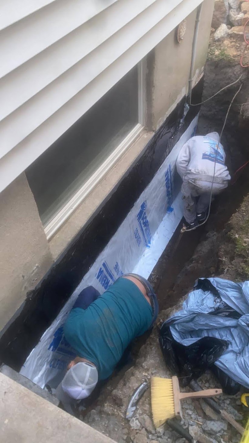 Kellets crew installing exterior foundation water-management layers
